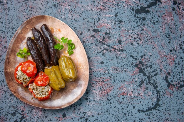 vista dall'alto dolma di melanzane con pomodori cotti e peperoni ripieni di carne macinata all'interno del piatto, piatto cena cibo colore