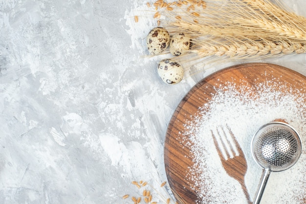 Vista dall'alto farina bianca a forma di cucchiaio e forchetta su tavola leggera torta uova dolci zucchero tè posate biscotto cuocere pasta spazio libero