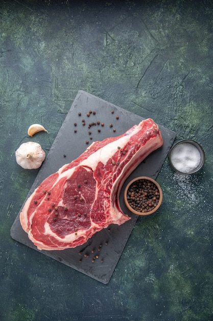 Vista dall'alto fetta di carne fresca carne cruda con pepe su sfondo scuro pasto di pollo foto colore cibo animale macellaio