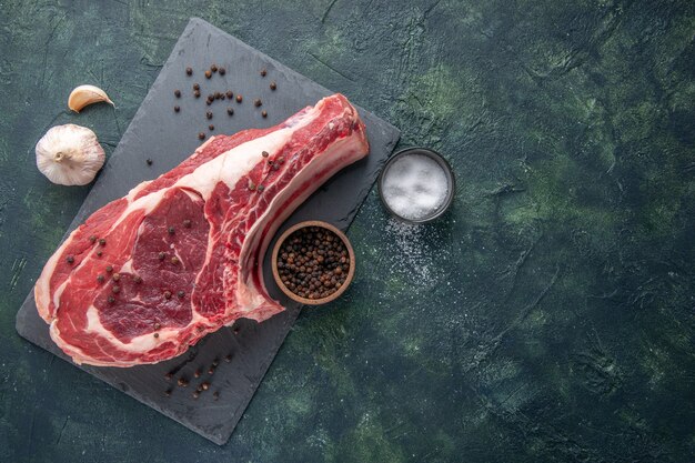 Vista dall'alto fetta di carne fresca carne cruda con pepe su sfondo scuro pasto di pollo foto colore cibo animale macellaio