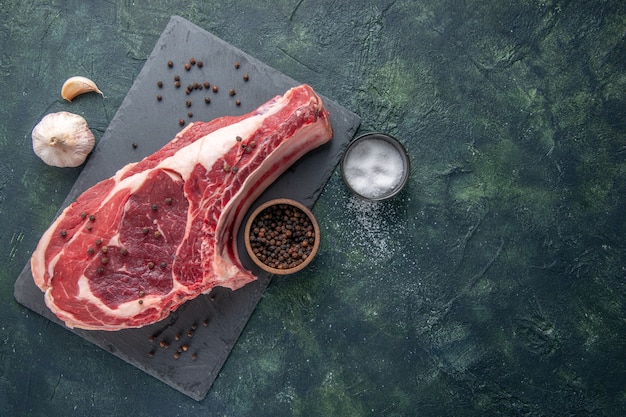 Vista dall'alto fetta di carne fresca carne cruda con pepe su sfondo scuro pasto di pollo foto colore cibo animale macellaio