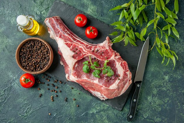 Vista dall'alto fetta di carne fresca con pomodori e pepe su sfondo blu scuro cucina animale mucca pollo carne colorante alimentare