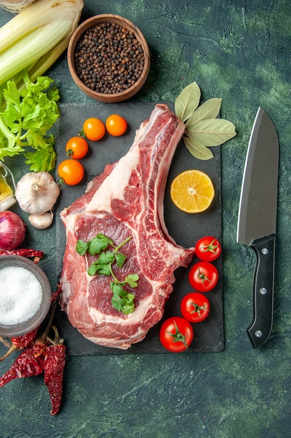 Vista dall'alto fetta di carne fresca con pomodori su sfondo blu scuro cibo carne cucina animale pollo colore mucca macellaio