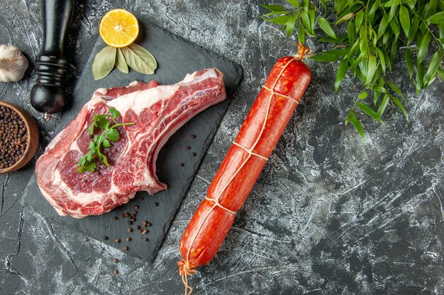 Vista dall'alto fetta di carne fresca con salsiccia su sfondo grigio chiaro cucina animale mucca carne di pollo colorante alimentare macellaio