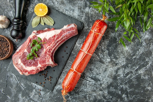 Vista dall'alto fetta di carne fresca con salsiccia su sfondo grigio chiaro cucina animale mucca carne di pollo colorante alimentare macellaio