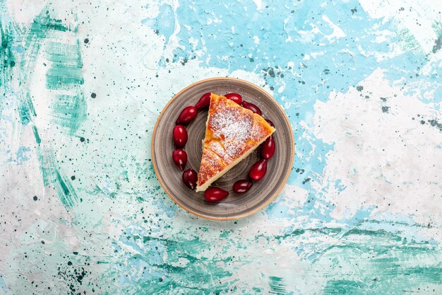 Vista dall'alto fetta di torta wit cornioli rossi freschi sulla superficie azzurra torta di frutta cuocere torta zucchero biscotto dolce