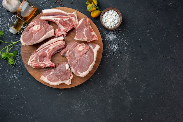 Vista dall'alto fette di carne fresca carne cruda su piatto barbecue scuro pepe cibo da cucina cibo per mucche farina animale