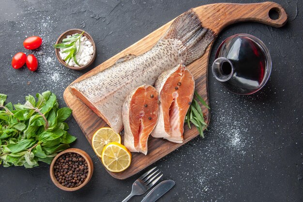 Vista dall'alto fette di pesce fresco con limone e verdure su sfondo scuro ristorante cena pasto frutti di mare cibo salutare carne oceano