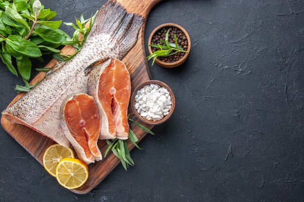 Vista dall'alto fette di pesce fresco con limone su sfondo scuro pasto colore acqua carne cibo oceano frutti di mare salute