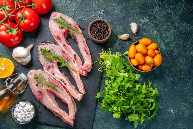 vista dall'alto fette di pesce fresco con pomodori rossi e verdure su sfondo scuro