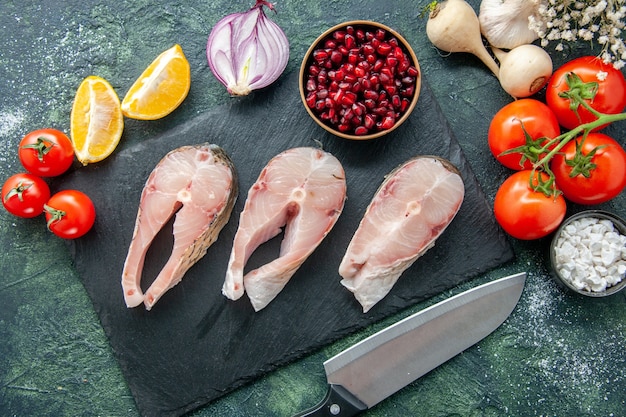 Vista dall'alto fette di pesce fresco con pomodori rossi su superficie scura frutti di mare oceano carne mare farina acqua pepe cibo insalata