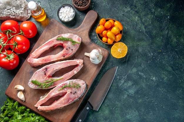 vista dall'alto fette di pesce fresco con pomodori su sfondo blu scuro