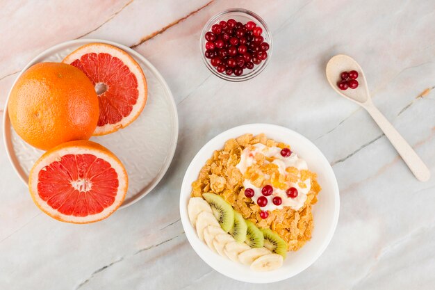 Vista dall'alto fette di pompelmo con yogurt e cornflakes