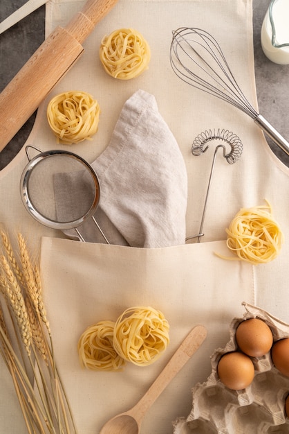 Vista dall'alto forniture con pasta e ingredienti in grembiule