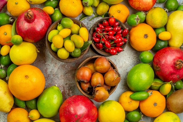 Vista dall'alto frutta fresca diversi frutti dolci sullo sfondo bianco dieta gustosa bacca colore foto salute albero maturo