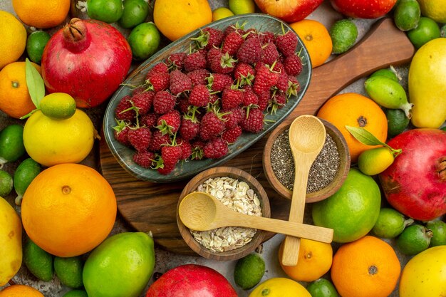 Vista dall'alto frutta fresca diversi frutti maturi e morbidi sullo sfondo bianco foto gustosa dieta a colori salute delle bacche