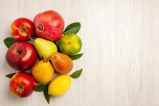 Vista dall'alto frutta fresca mele pere e altri frutti sulla scrivania bianca frutta albero maturo colore morbido molti freschi