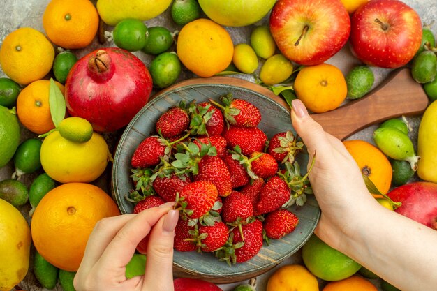 Vista dall'alto frutti freschi diversi frutti maturi e morbidi su uno sfondo bianco salute gustosa dieta a colori bacca