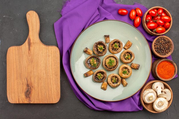 Vista dall'alto funghi cotti all'interno del piatto con condimenti su piatto in tessuto viola funghi cottura della cena