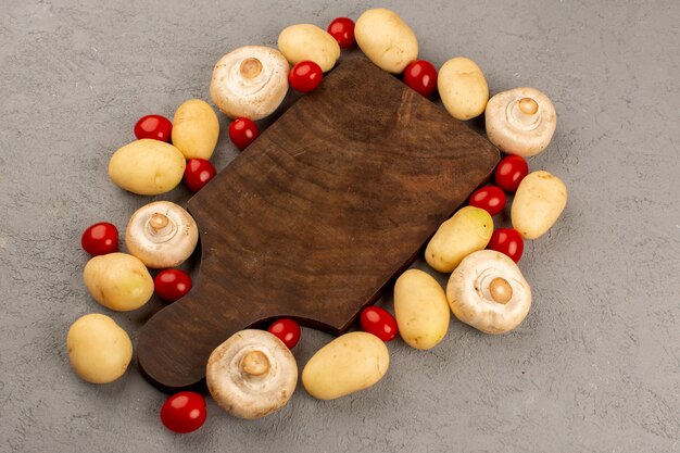 vista dall'alto funghi patate pomodori freschi maturi sul grigio