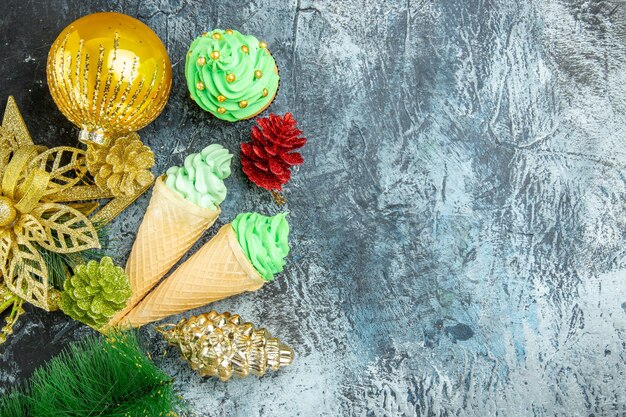 Vista dall'alto gelati albero di natale cupcake ornamenti di natale su sfondo grigio