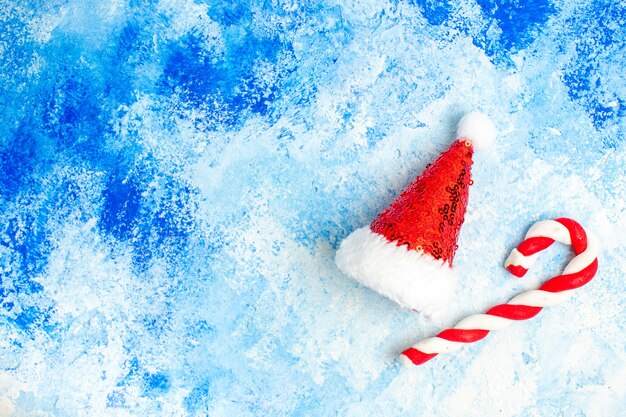 Vista dall'alto giocattolo dell'albero di natale del cappello di babbo natale sul tavolo blu con spazio libero