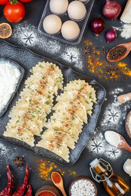 Vista dall'alto gnocchi cotti con ingredienti diversi sullo sfondo scuro piatto di verdure cena cucinare pasta colorata