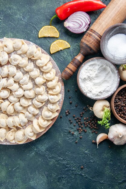 Vista dall'alto gnocchi crudi con farina e verdure su sfondo scuro pasta di carne cibo calorie colore pasto vegetale