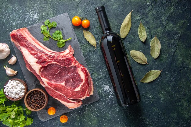 Vista dall'alto grande fetta di carne carne cruda con pepe e verdure su superficie scura