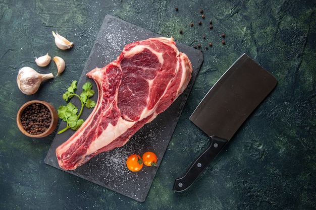 Vista dall'alto grande fetta di carne carne cruda con pepe su superficie scura