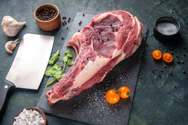 Vista dall'alto grande fetta di carne carne cruda con pepe su superficie scura