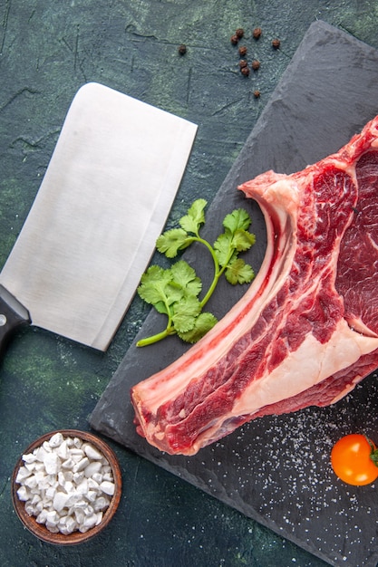 Vista dall'alto grande fetta di carne carne cruda con verdure su superficie scura