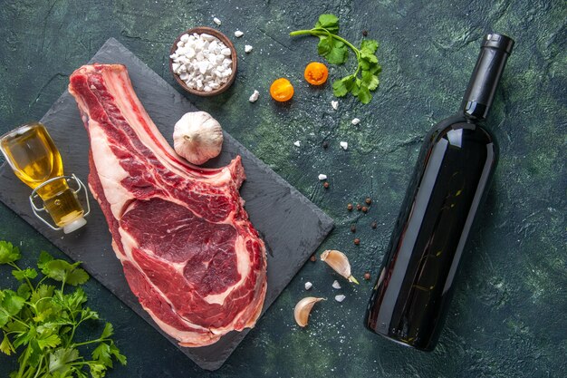 Vista dall'alto grande fetta di carne carne cruda con verdure su superficie scura