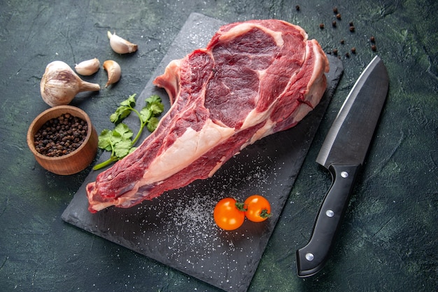 Vista dall'alto grande fetta di carne carne cruda su superficie scura