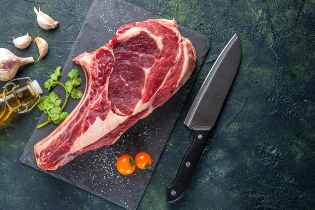 Vista dall'alto grande fetta di carne carne cruda su superficie scura