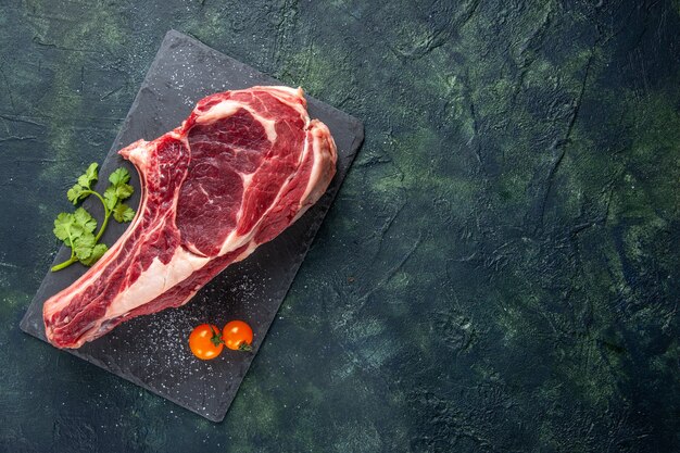 Vista dall'alto grande fetta di carne carne cruda su superficie scura