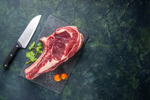 Vista dall'alto grande fetta di carne carne cruda su superficie scura