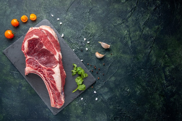 Vista dall'alto grande fetta di carne carne cruda su superficie scura