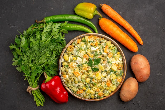 Vista dall'alto gustosa insalata con verdure e verdure fresche su sfondo scuro