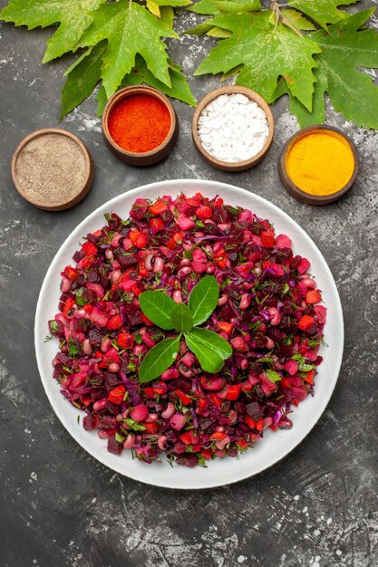 Vista dall'alto gustosa insalata di barbabietola vinaigrette con condimenti sulla superficie scura