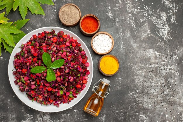 Vista dall'alto gustosa insalata di barbabietola vinaigrette con condimenti sulla superficie scura