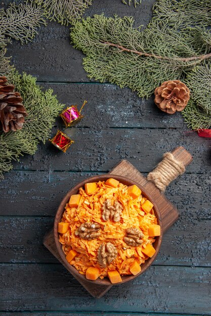 Vista dall'alto gustosa insalata di carote con noci su sfondo blu scuro insalata di salute colore dieta alimentare dado