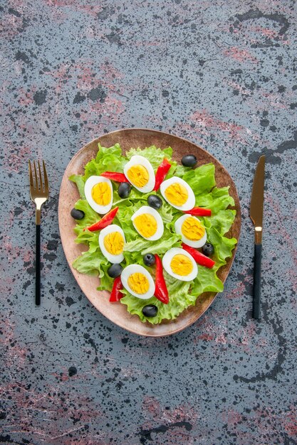 vista dall'alto gustosa insalata di uova con insalata verde e olive su sfondo chiaro