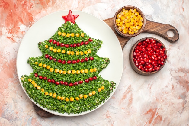 Vista dall'alto gustosa insalata di vacanza a forma di albero di Capodanno sullo sfondo chiaro