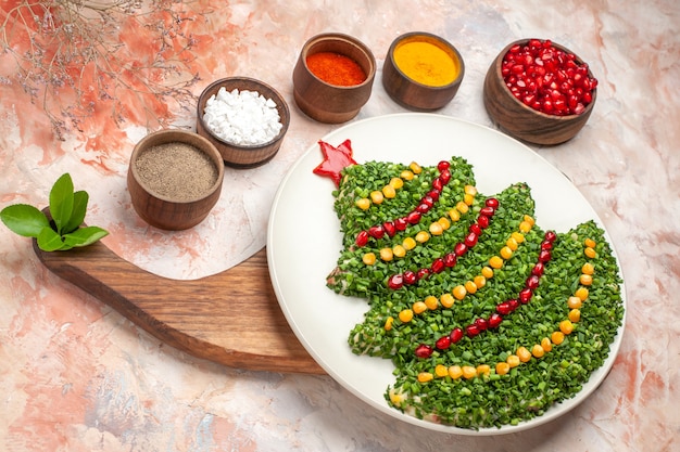 Vista dall'alto gustosa insalata di vacanza a forma di albero di Capodanno sullo sfondo chiaro