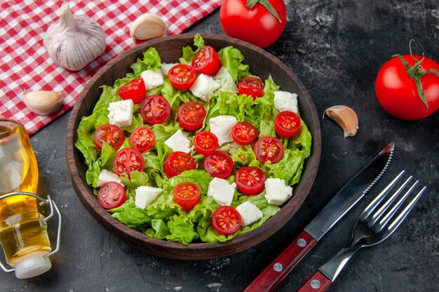 Vista dall'alto gustosa insalata di verdure con formaggio a fette pomodori e condimenti su uno sfondo scuro colore cibo pasto dieta pranzo salute