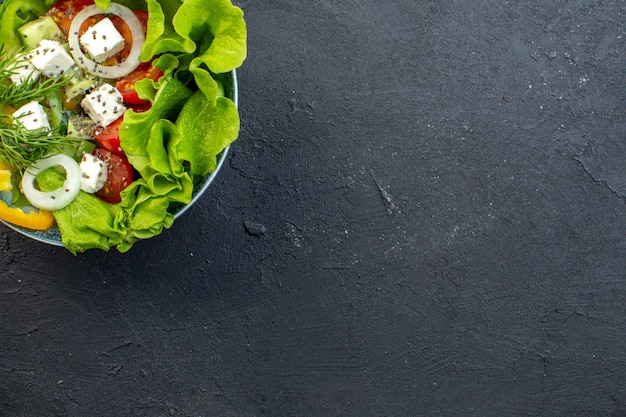 vista dall'alto gustosa insalata di verdure con formaggio cetrioli e pomodori su sfondo scuro