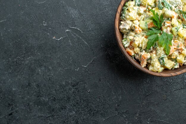 Vista dall'alto gustosa insalata maionese all'interno del piatto marrone su grigio