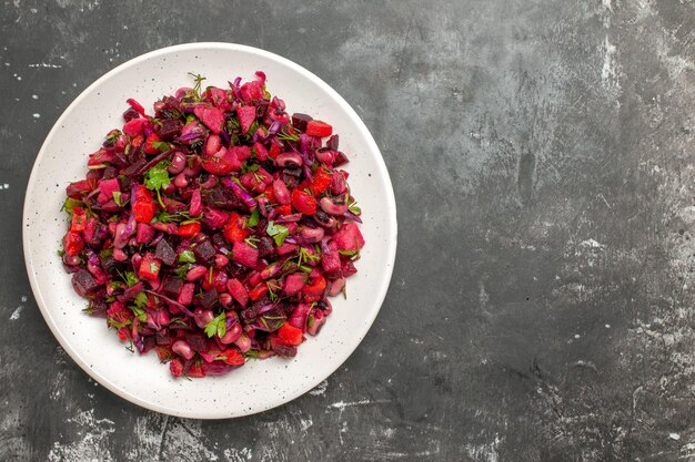 Vista dall'alto gustosa insalata vinaigrette con fagioli e barbabietole sulla scrivania grigia