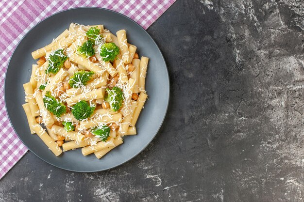 Vista dall'alto gustosa pasta cotta con broccoli e condimenti su sfondo grigio chiaro pasto fotografico a colori pasta italiana cibo